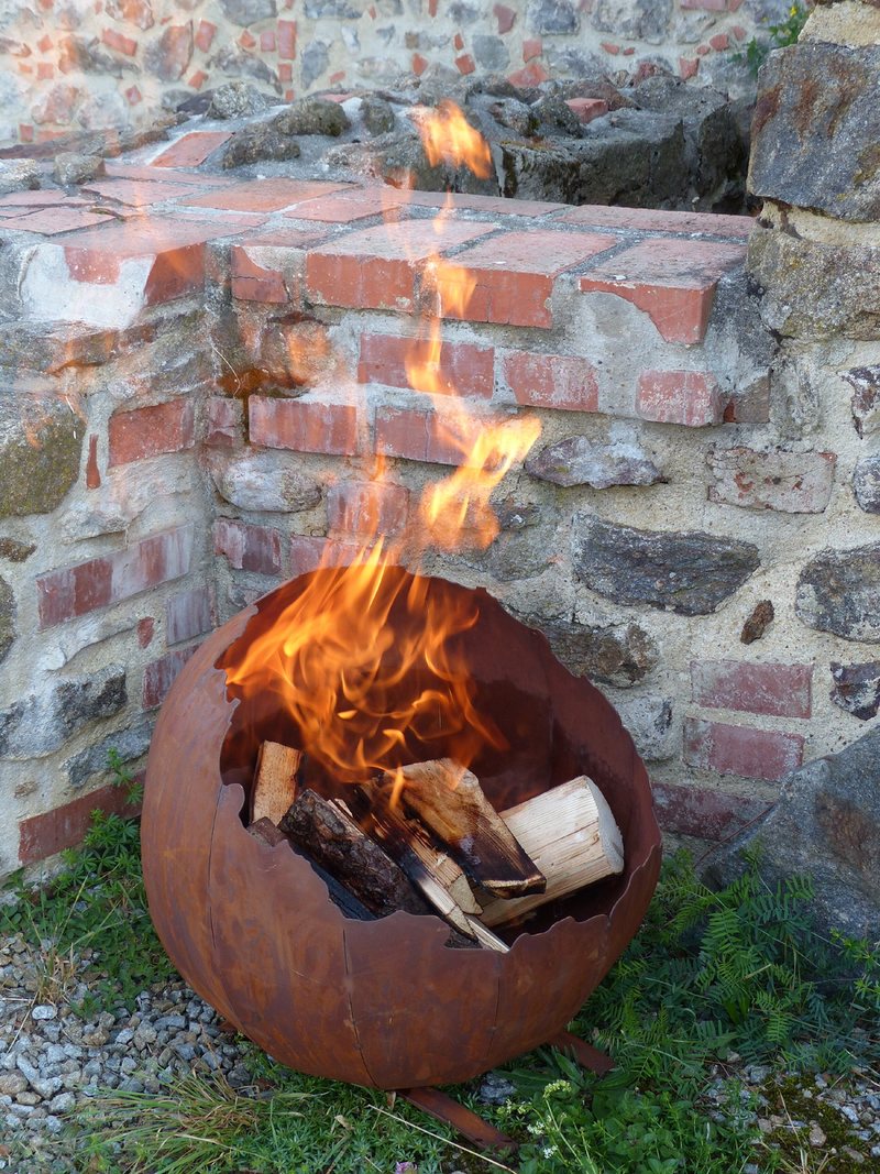 Feuerkugel Sunna mit Feuer vor einer Natursteinmauer